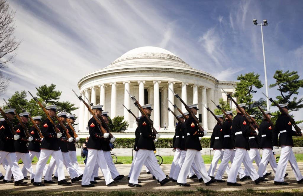 The Marine Corps Silent Drill Platoon marches in front of the Thomas Jefferson Memorial on their way to perform for the Cherry Blossom Festival in Washington April 12, 2014. | U.S. Marine Corps