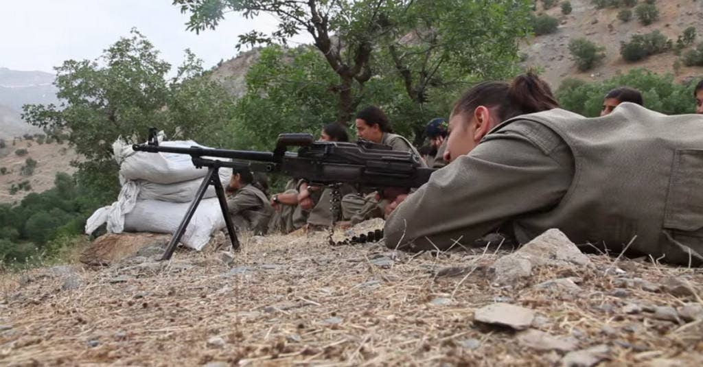 A military trainer teaches Yazidi and Kurdish women how to fire machine guns during basic training. Screenshot: YouTube/BBC News