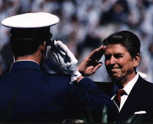 President Reagan salutes a military cadet (wikimedia commons)