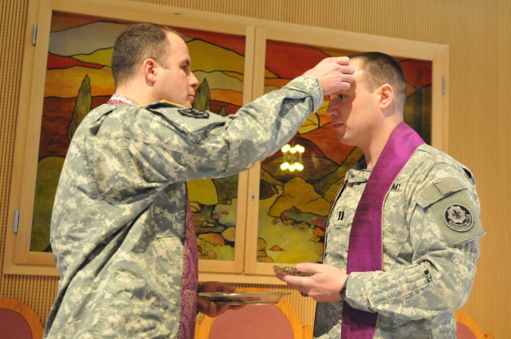 U.S. Army Capt. Christopher Butera (left), chaplain of the Fires Squadron, 2nd Cavalry Regiment, receives ashes from Capt. Robert Allman, chaplain of the 2nd Cavalry Regiment. The Regiment hosted a prayer breakfast in observance of Ash Wednesday. (U.S. Army Photo by Spc. Joshua Edwards)