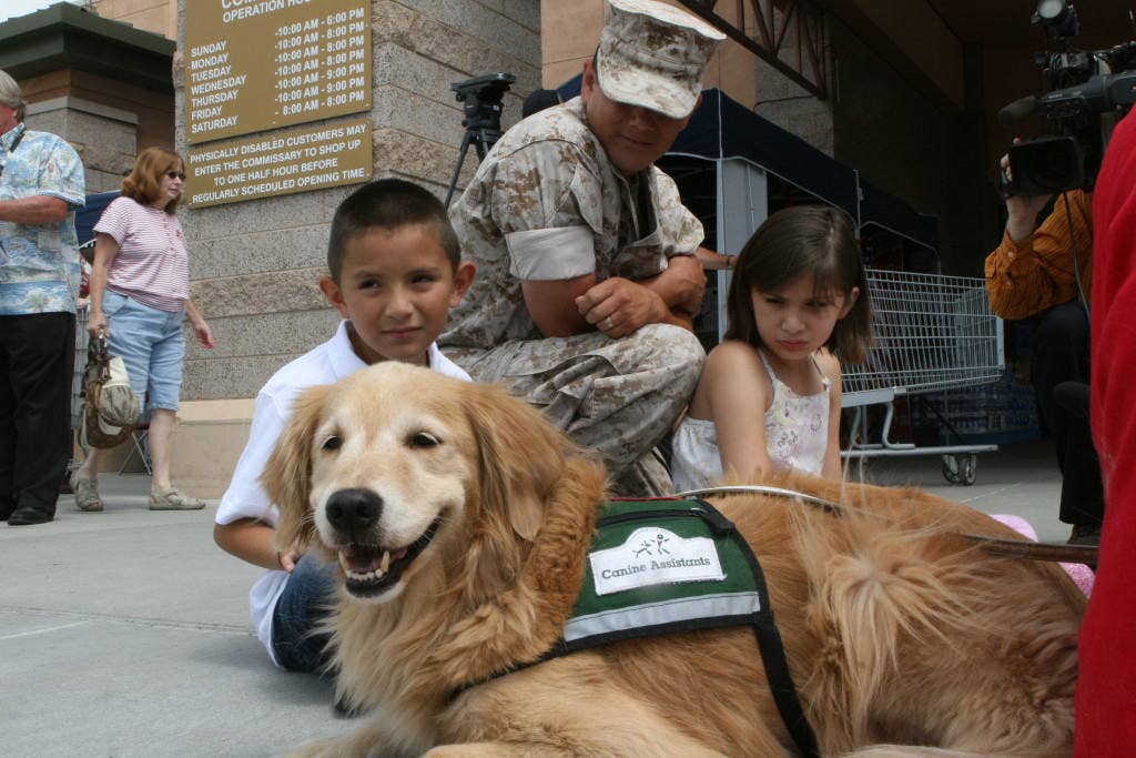 Adamari Muniz, 10, and her family meet a service dog at the Defense Commissary Agency here July 29. Milk-Bone and the DCA will donate a dog to Adamari, who suffers from epilepsy. A service dog can alleviate many of the tasks she finds difficult and give her more independence in that she will not have to ask for constant assistance.