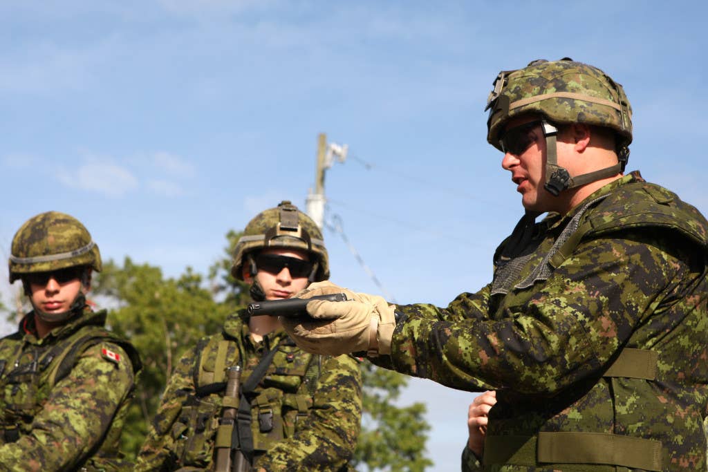 Canadian soldiers of Alpha Company, 3rd Battalion, 22nd Regiment, Canadian Royal Army, inspect their Browning Hi-Power 9 mm pistols prior to training on the firing range at Camp Blanding, Fla., in support of Partnership of the Americas 2009. U.S. Marine Corps photo by Lance Cpl. Christopher J. Gallagher.
