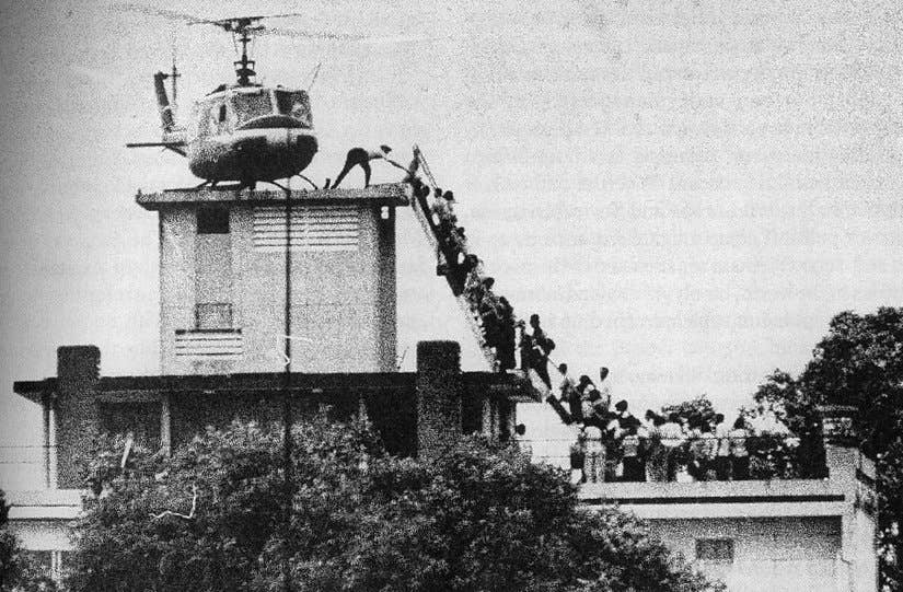A member of the CIA helps evacuees up a ladder onto an Air America helicopter on the roof of 22 Gia Long Street April 29, 1975, shortly before Saigon fell to advancing North Vietnamese troops.