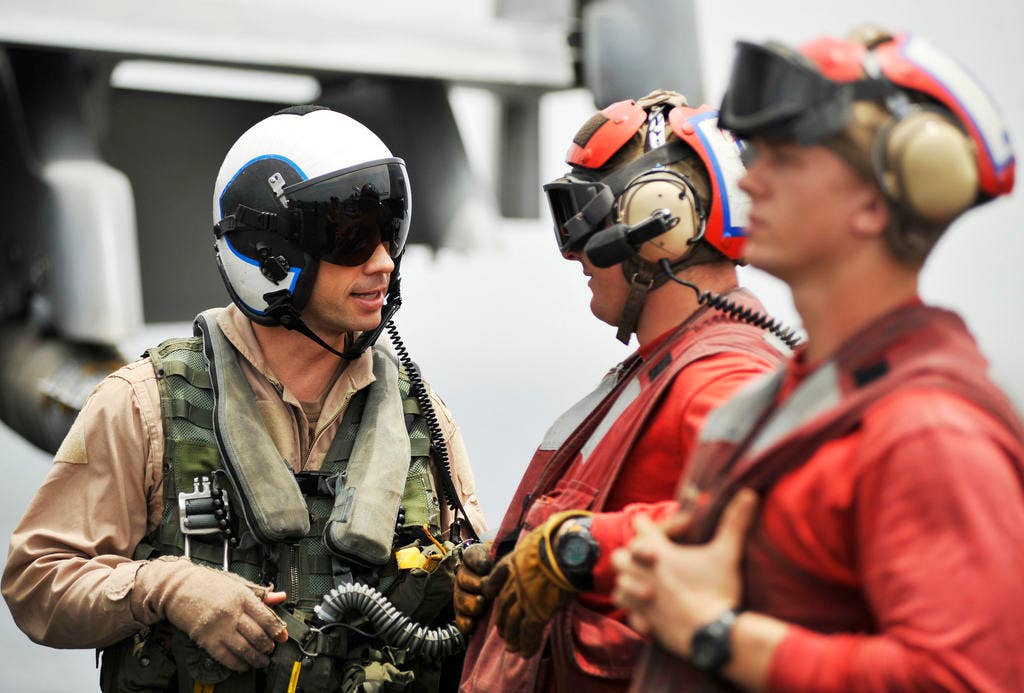 Cmdr. Chad Vincelette, executive officer of the Swordsmen of Strike Fighter Squadron (VFA) 32, speaks with an aviation ordnanceman aboard the aircraft carrier USS Harry S. Truman (CVN 75) before his flight to support Operation Enduring Freedom. (Photo: U.S. Navy/Mass Communication Specialist 2nd Class Kilho Park)