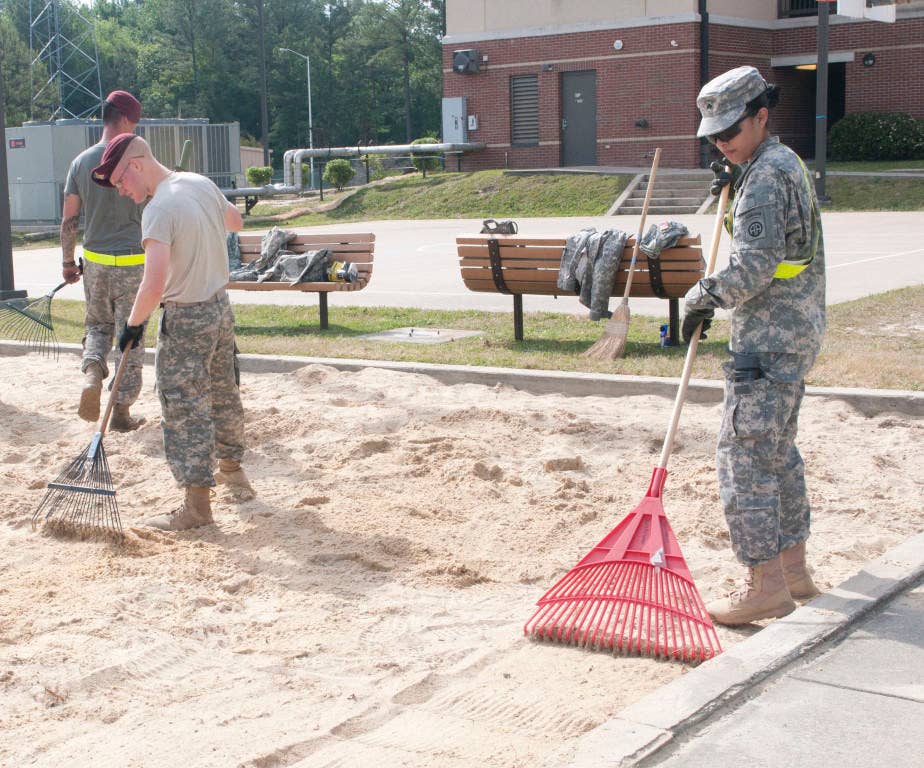 Sgt. Bridgett Gomez, Headquarters and Headquarters Company and Pvt. Joshua Barker, Company D, 1st Attack Reconnaissance Battalion, 82nd Combat Aviation Brigade, rake through the remaining sand of the volleyball court outside their barracks after removing large clumps of grass in preparation of new sand, March 16. (Photo by U.S. Army Sgt. April D. de Armas, 82nd Combat Aviation Brigade Public Affairs)