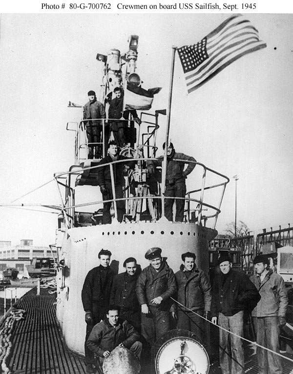 The USS Sailfish crew pose on the conning tower. Their Presidential Unit Citation Flag is visible flying behind the American flag. Photo: US National Archives