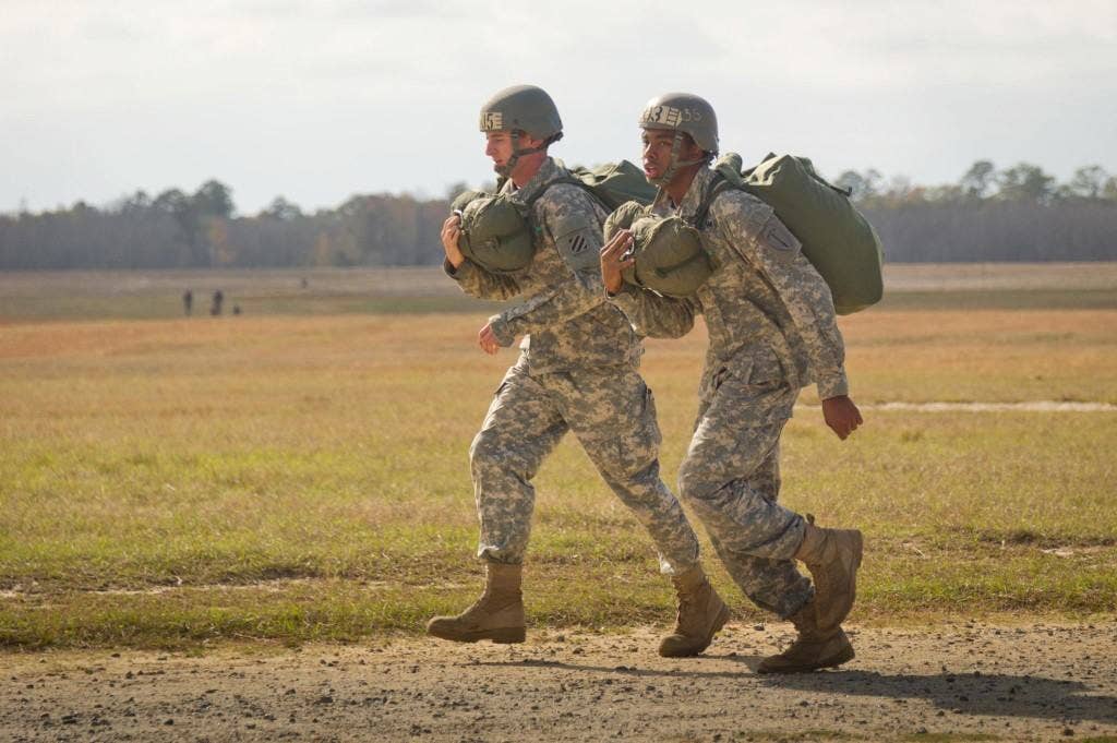 Army 2nd Lt. Nelson Lalli runs with an Airborne School classmate to report in after his first jump.