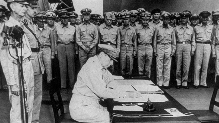 MacArthur signing the articles of surrender aboard the USS Missouri anchored in Tokyo Bay in 1945.