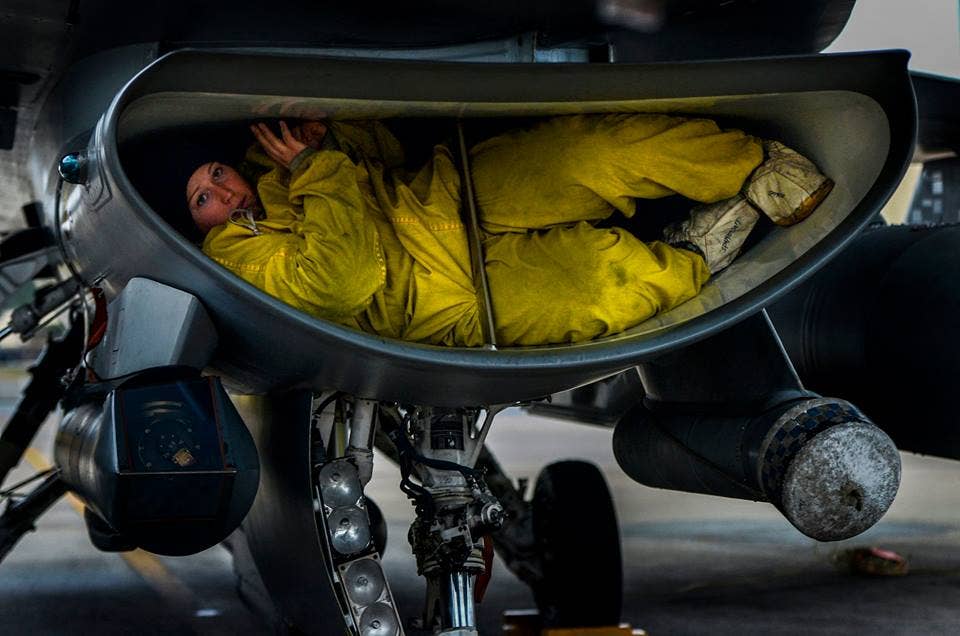 A U.S. Air Force crew chief assigned to the 77th Fighter Squadron, crawls out of the intake of an F-16 Fighting Falcon as she completes her post flight inspection on the aircraft, Jan. 15, 2015, Shaw Air Force Base, S.C. Crews chiefs work around the clock to keep Shaw's fleet of F-16 Fighting Falcons mission ready at all times.(U.S. Air Force photo by Staff Sgt. Kenny Holston)