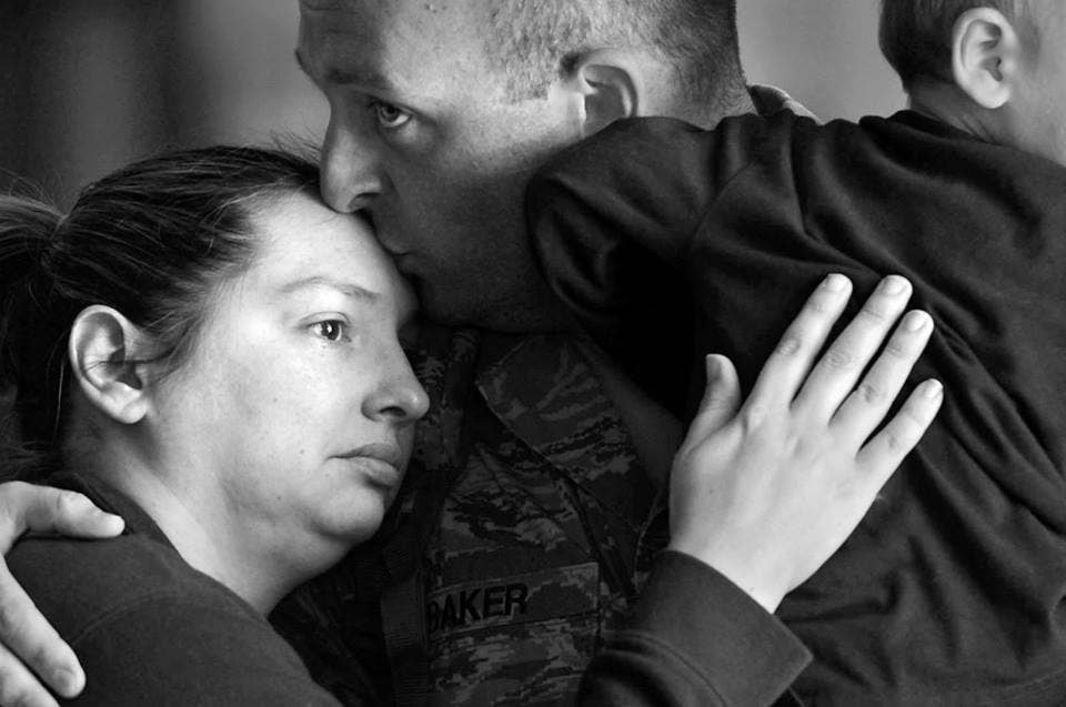 U.S. Air Force Staff Sgt. Brett Baker, assigned to the 20th Fighter Wing, kisses his wife before leaving for a deployment from Shaw Air Force Base, S.C., Oct. 6, 2015. Members of the Air Force typically deploy several times throughout their career, often times leaving family members behind. (U.S. Air Force photo by Senior Airman Jensen Stidham)