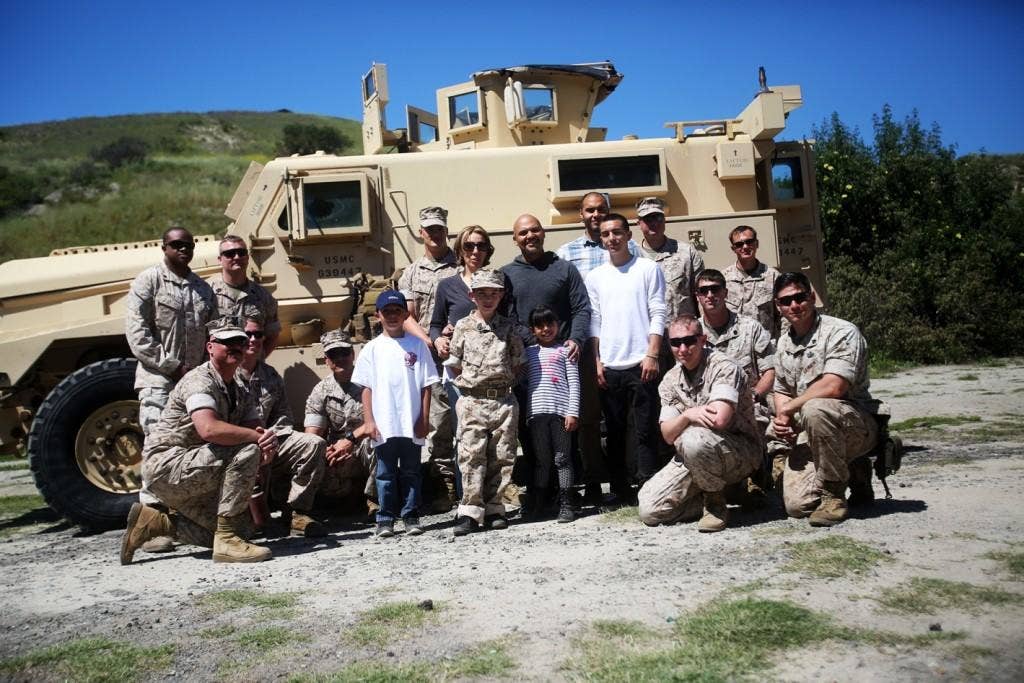 Nathan Aldaco, a 12 year-old boy with hypoplastic left heart syndrome, and his family, pose for a picture with Explosive Ordnance Disposal Marines during a Make-A-Wish event. (U.S. Marine Corps photo by Sgt. Laura Gauna)