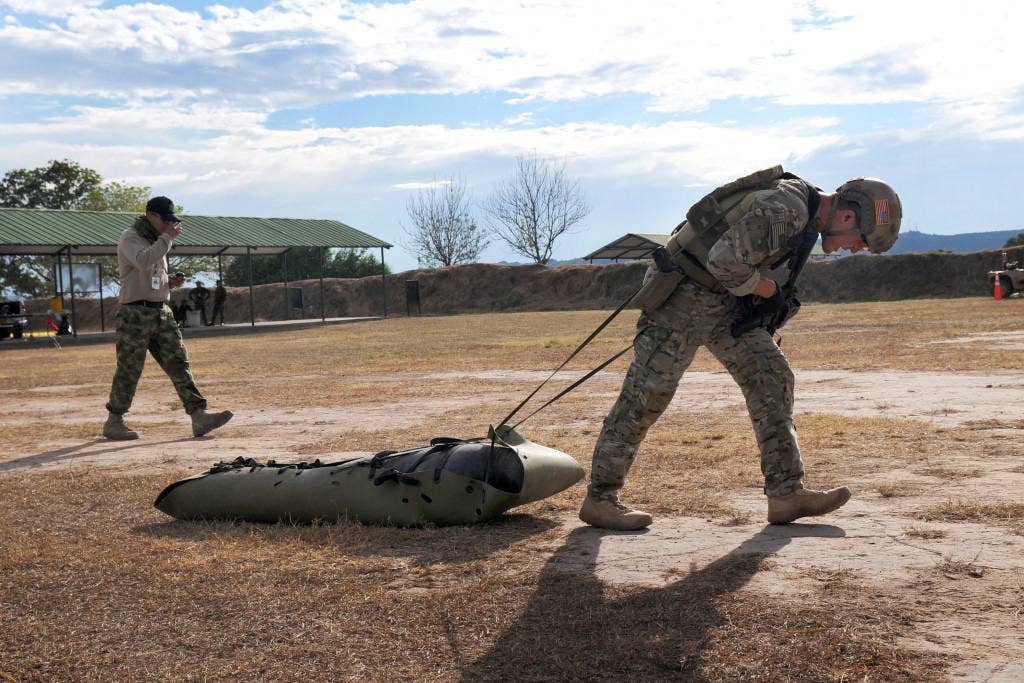 A member of the U.S. team pulls an evacuation sled loaded with a 250-pound mannequin to a range during the Fuerzas Comando Stress Test event. (U.S. Army photo by Sgt. Wilma Orozco Fanfan)