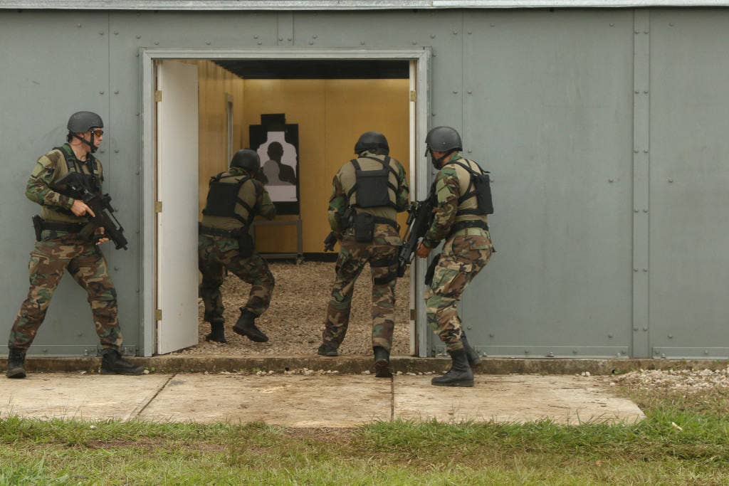 Members of the Uruguayan assault team breach a doorway during a live-fire shoot house. (U.S. Army photo by Staff Sgt. Michael Carden)