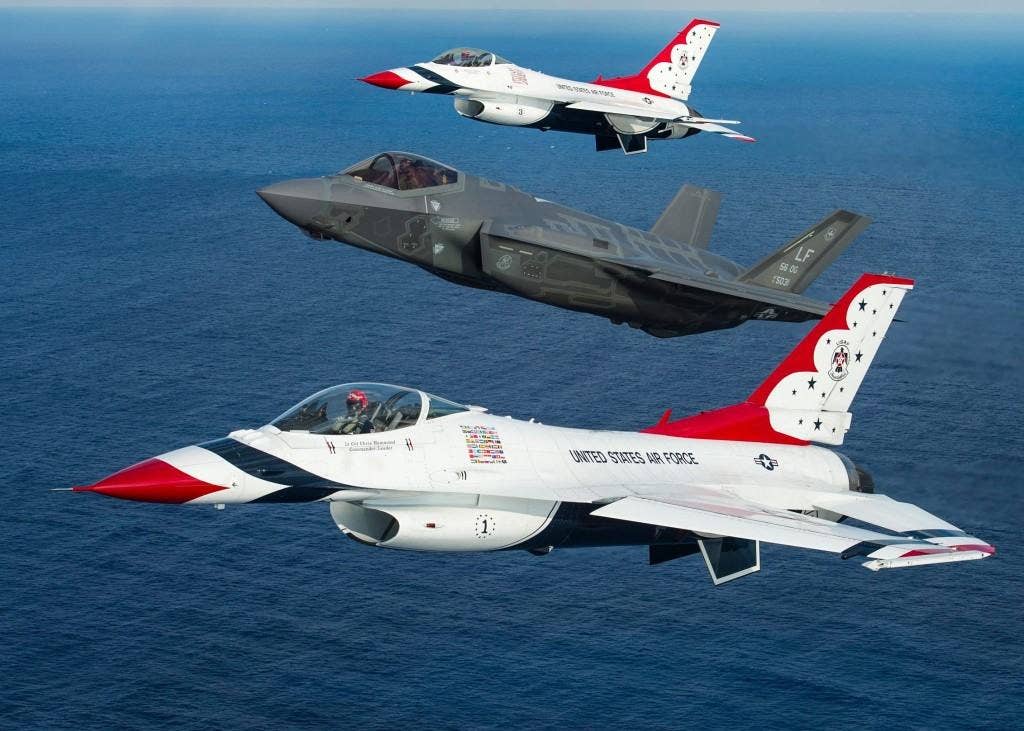 An F-35 flies at a high angle of attack relative to the US Air Force Thunderbird F-16s on either side of it. | USAF photo