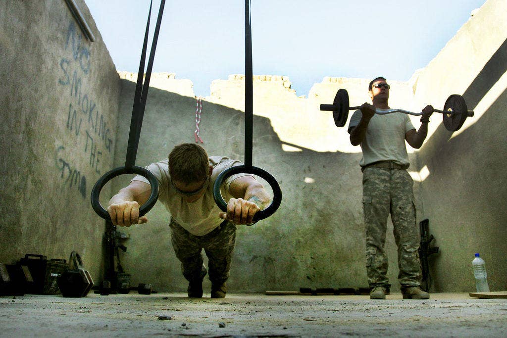 U.S. Army Staff Sergeants Brian Weaver, left, from Philadelphia, and Matt Leahart, from O'Fallon, Mo., use exercise equipment in a room that has been converted into the gym on Combat Outpost Munoz, Paktika province, Afghanistan.