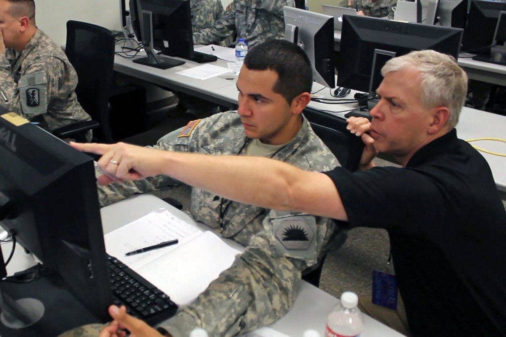 Military and civilian computer network analysts with the California Army National Guard Computer Network Defense Team tackle a simulated virus attack. (Photo by Capt. Kyle Key)