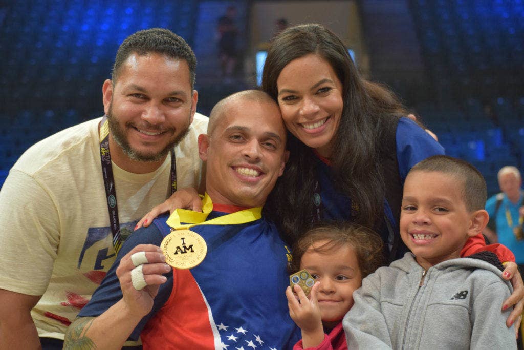 Navy Fire Controlman 3rd Class (ret.) Jason Reyes poses with his family and Dario Santana, Warrior Games' Family Programs and Charitable Resource Coordinator, after the U.S. team wins the gold in wheelchair basketball at the Invictus Games May 12, 2016 in Orlando, Fla. (U.S. Navy photo by Lt. j.g. Marissa A. Cruz)