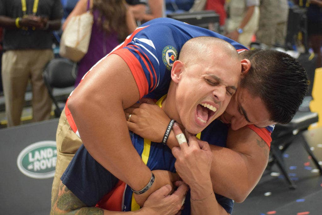 Navy Fire Controlman 3rd Class Jason Reyes (ret.) shares an embrace with a fellow U.S. team member after winning the gold medal in wheelchair basketball against the United Kingdom at the Invictus Games May 12 in Orlando, Fla. (U.S. Navy photo by Lt. j.g. Marissa A. Cruz)