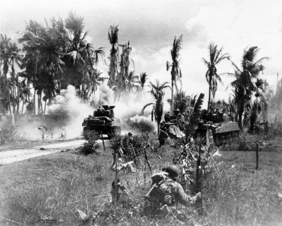 U.S. Troops of the 185th Inf., 40th Div., take cover behind advancing tanks while moving up on Japanese positions on Panay Island (Library of Congress)