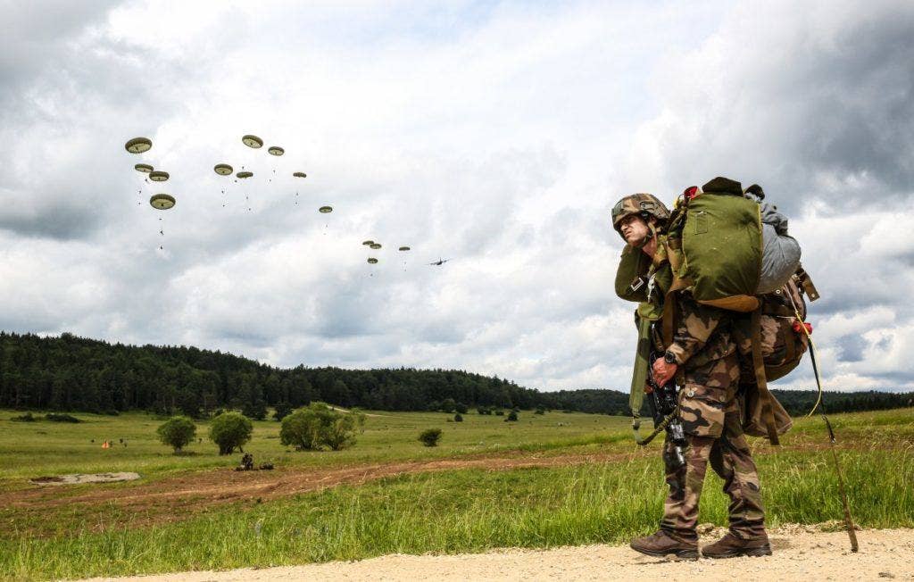 A French paratrooper watches other airborne soldiers descend from a C-130. (Photo: U.S. Army Spc. Lloyd Villanueva)