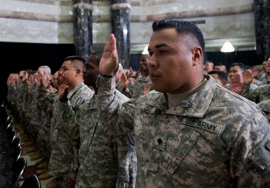 Spc. Samuel Diaz and 155 other service memembers take the Oath of Citizenship during a naturalization ceremony July 4 2010 in the Al Faw Palace rotunda at Camp Victory, Iraq U.S. Citizenship and Immigration Services, administered the Oath of Citizenship. (DoD Photo by Lee Craker)
