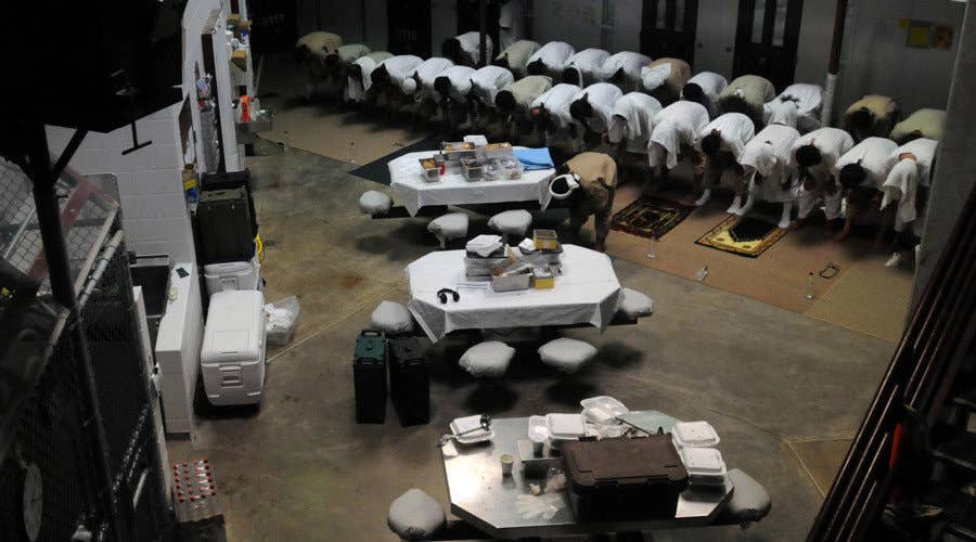 Detainees at the U.S. prison at Guantanamo Bay during prayer (DoD photo)