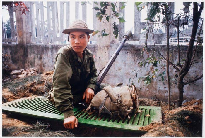 A North Vietnamese soldier atop his foxhole (Photo by Catherine Leroy)