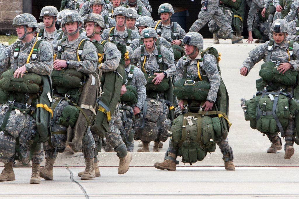 Paratroopers with the 82nd Airborne Division's 1st Brigade Combat Team walk toward aircraft as they prepare for a mass-tactical airborne training exercise Feb. 25, 2013, Pope Army Airfield, Fort Bragg, N.C. Many of the paratroopers are carrying in excess of 100 pounds of gear. | U.S. Army photo by Sgt. Michael J. MacLeod