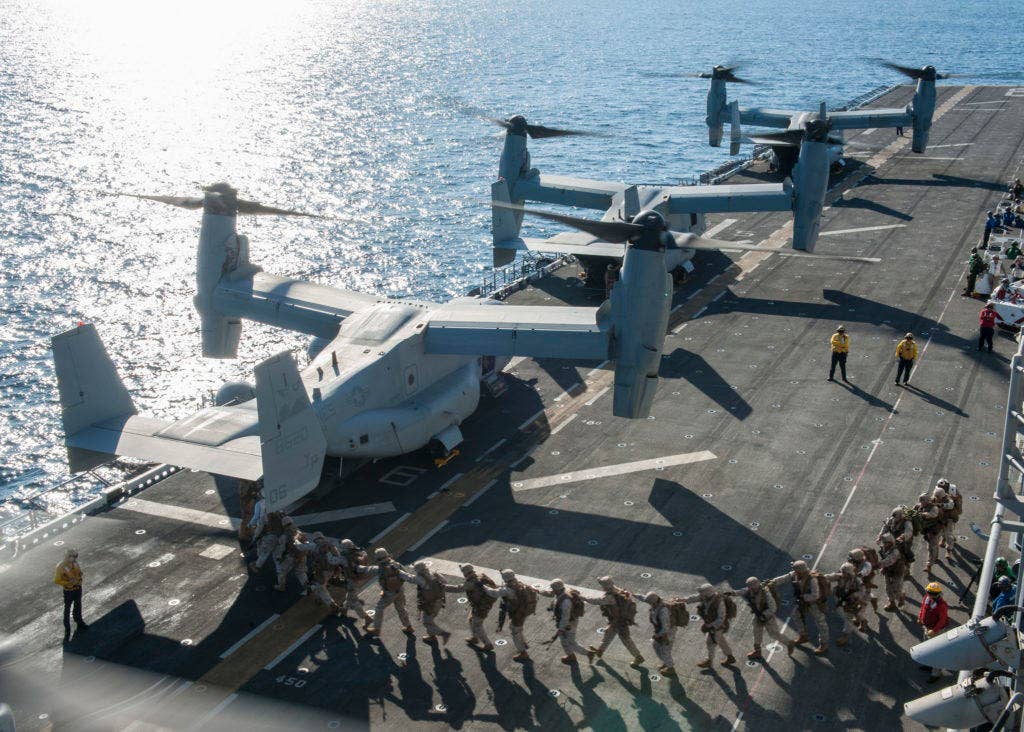 Marines assigned to the 11th Marine Expeditionary Unit (MEU) board an MV-22 Osprey, assigned to Marine Medium Tiltrotor Squadron (VMM) 163 (Reinforced) on the flight deck of the amphibious assault ship USS Makin Island (LHD 8). (U.S. Navy photo by Mass Communication Specialist Seaman Devin M. Langer)