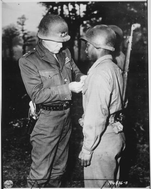 Patton pins a Silver Star Medal on Private Ernest A. Jenkins, a soldier under his command, October 1944 (Army photo)