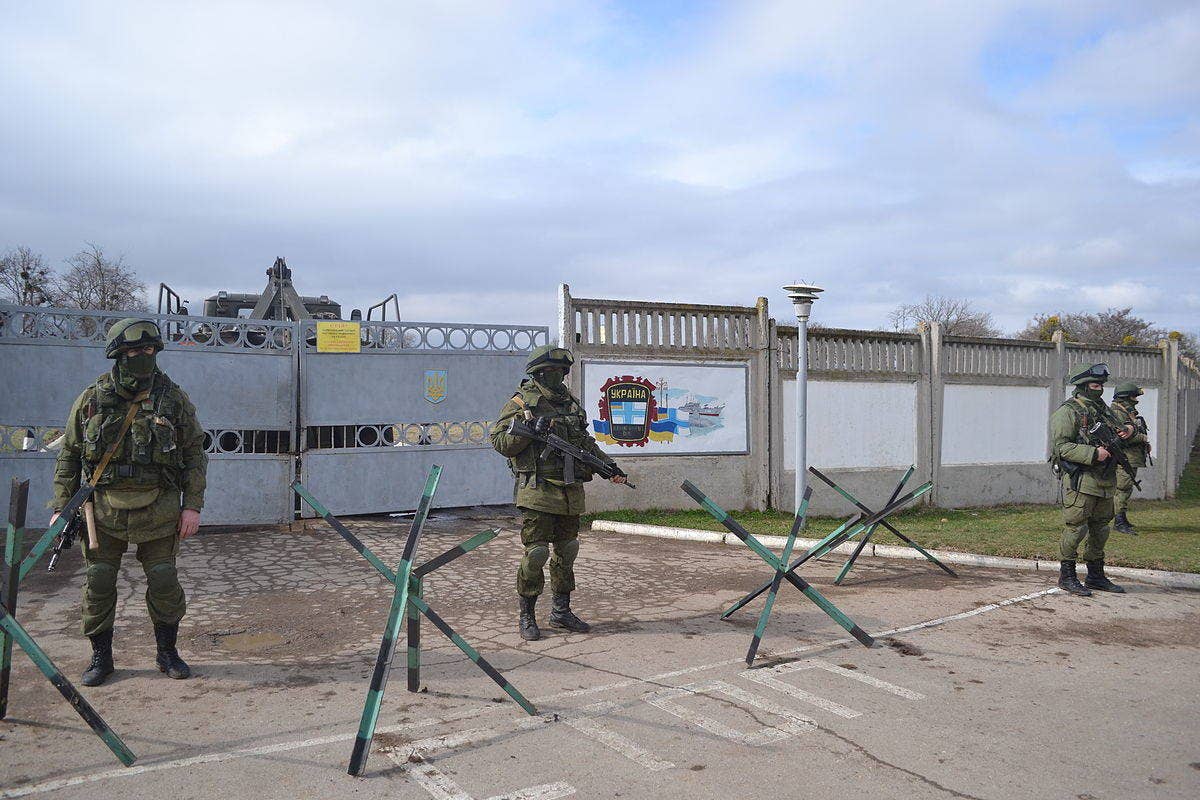 Russian soldiers in modified uniforms with no national markings stand guard outside a captured Ukrainian base in 2014. (Photo: Anton Holoborodko CC BT-SA 3.0)