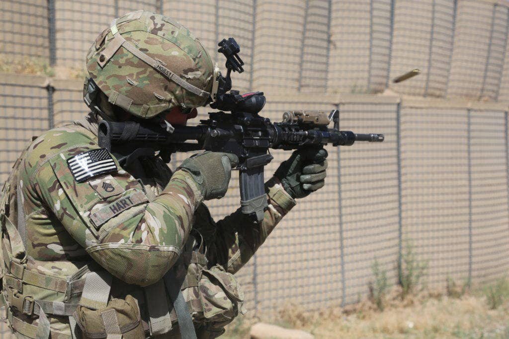 U.S. Staff Sgt. Chad Hart with Green 0 Security Force Advisory Team, 10th Mountain Division, fires his M4 carbine down range on Khair Kot Garrison, Paktika province, Afghanistan, June 2, 2013. Staff Sgt. Hart assumed the standing firing position for qualification. (U.S. Army Photo by Spc. Chenee' Brooks/ Released)