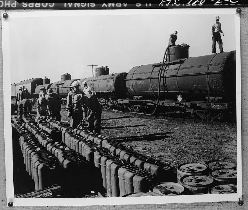 U.S. Army soldiers fill 5-gallon jugs from a gasoline tank on a railroad car during the 1941 Louisiana Maneuvers. (Photo: US Army Signal Corps)