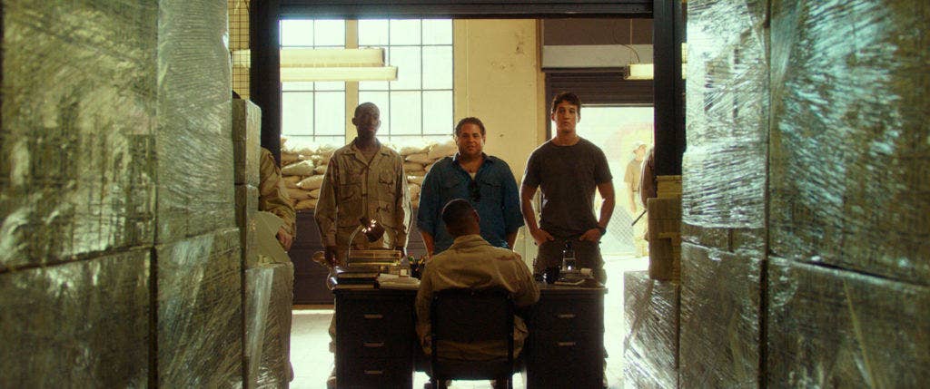 Efraim Diveroli and David Packouz, played by Jonah Hill and Miles Teller, stand in a warehouse of cash managed by the U.S. Army in Iraq. (Photo: courtesy of Warner Bros. Pictures)