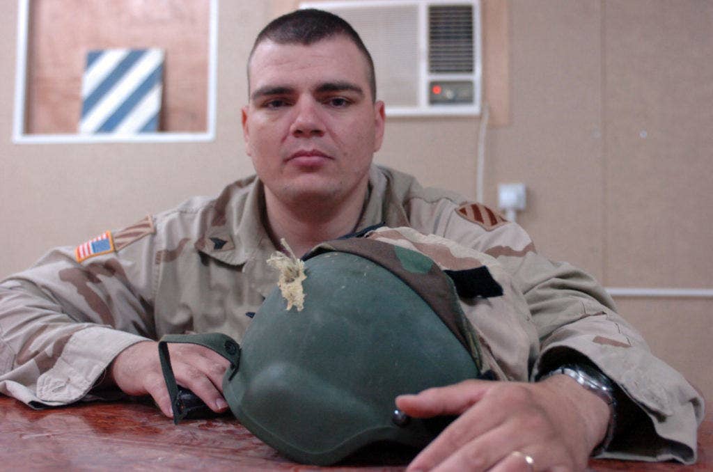 Sgt. Shawn Snyder displays the helmet that saved his life from a sniper in downtown Tikrit, Iraq. (Photo: U.S. Army Sgt. 1st Class Mark Wojciechowski)