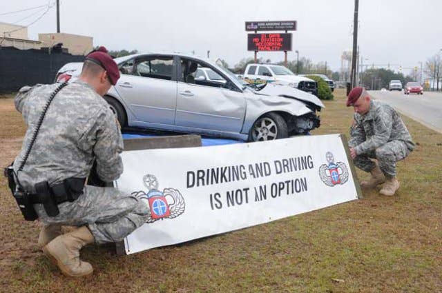 Fort Bragg military police hang a banner near a wrecked car in 2013. The car and banner served as a reminder to soldiers to not drink and drive. (Photo: U.S. Army Sgt. Kissta DiGregorio)