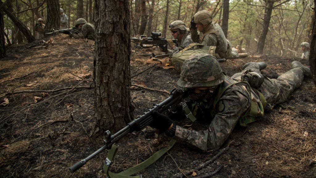 U.S. Soldiers set up a support by fire line alongside their Republic of Korea (ROK) Army Soldier counterparts when reacting to enemy contact during a platoon live fire training blank iteration on Rodriguez Live Fire Complex, near the DMZ, Republic of Korea, March 21, 2015, during joint training exercise Foal Eagle 2015. (U.S. Army photo by Spc. Steven Hitchcock)