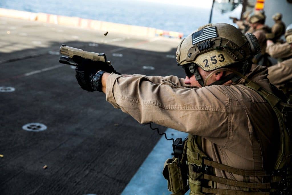 Marine Cpl. Alex Daigle fires at his target with an M45 1911 A1 pistol during a deck shoot aboard the amphibious assault ship USS Essex (LHD 2). (U.S. Marine Corps photo by Cpl. Anna Albrecht/Released)