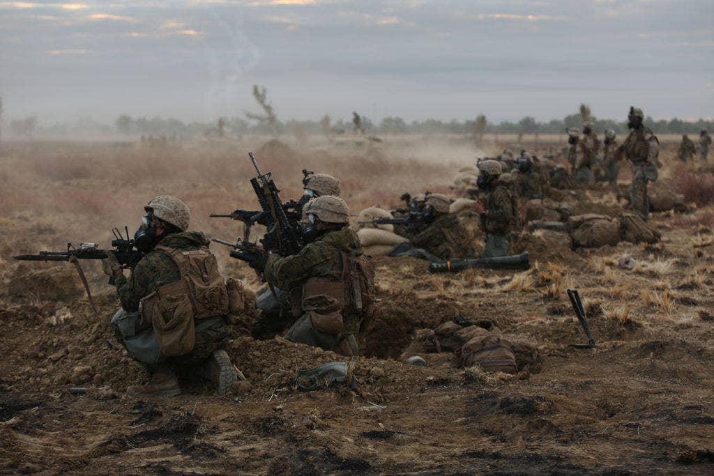 Marines with Company C, 1st Battalion, 1st Marine Regiment, fire down range during a CS gas attack during a live fire range August 18, 2016, at Bradshaw Field Training Area, Northern Territory, Australia. The range was the final training evolution of Exercise Koolendong 16, a trilateral exercise between the U.S. Marine Corps, Australian Defence Force and French Armed Forces New Caledonia. Marines held a defensive position while engaging targets and working through the CS gas, which simulated a chemical attack. (U.S. Marine Corps photo by Sgt. Sarah Anderson)
