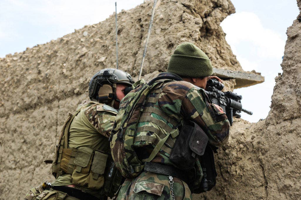 A U.S. Special Forces soldier, attached to Combined Joint Special Operations Task Force-Afghanistan, and an Afghan National Army commando, of 6th Special Operations Kandak, scan the area for enemy movement after taking direct fire from insurgents during an operation in Khogyani district, Nangarhar province, Afghanistan, March 20, 2014. Commandos, advised and assisted by U.S. Special Forces soldiers, conducted the operation to disrupt insurgent freedom of maneuver. (U.S. Army photo by Spc. Connor Mendez)