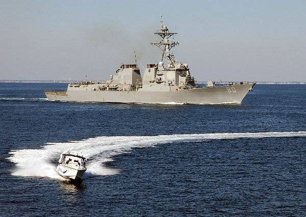 The Arleigh Burke-class guided missile destroyer USS Roosevelt (DDG 80) and a small boat participate in a simulated small boat attack exercise (SWARMEX) in 2004. (Photo: U.S. Navy)