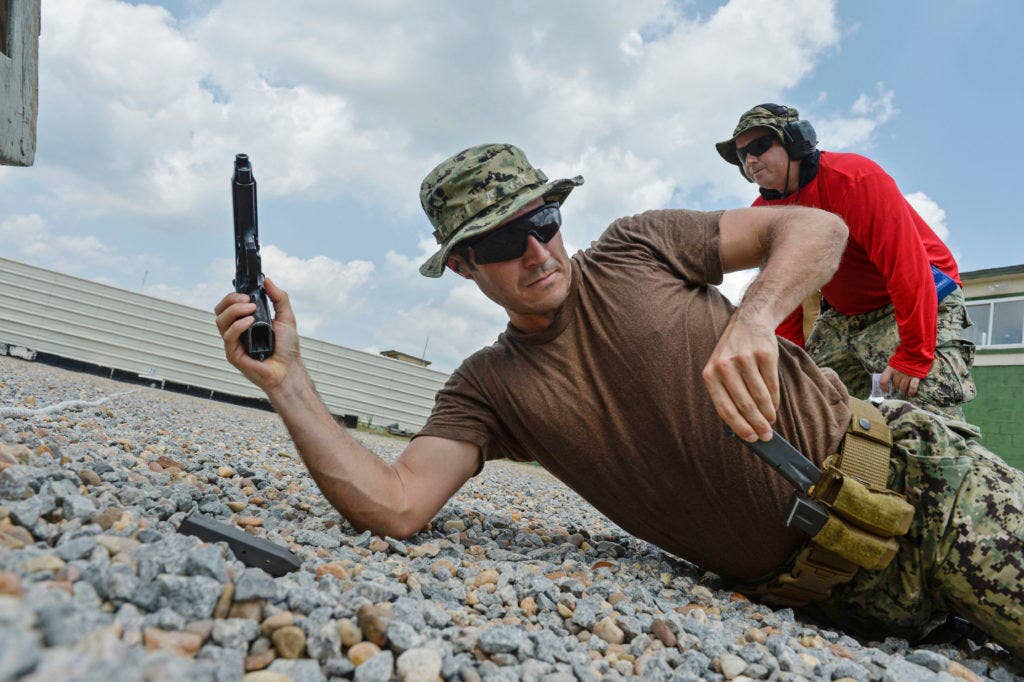 Mass Communication Specialist 3rd Class Jesse Paquin, assigned to Expeditionary Combat Camera reloads an M9 pistol during practical weapons course training at Naval Support Activity Northwest Annex, July 28. (U.S. Navy photo by Chief Mass Communication Specialist Eric Dietrich)