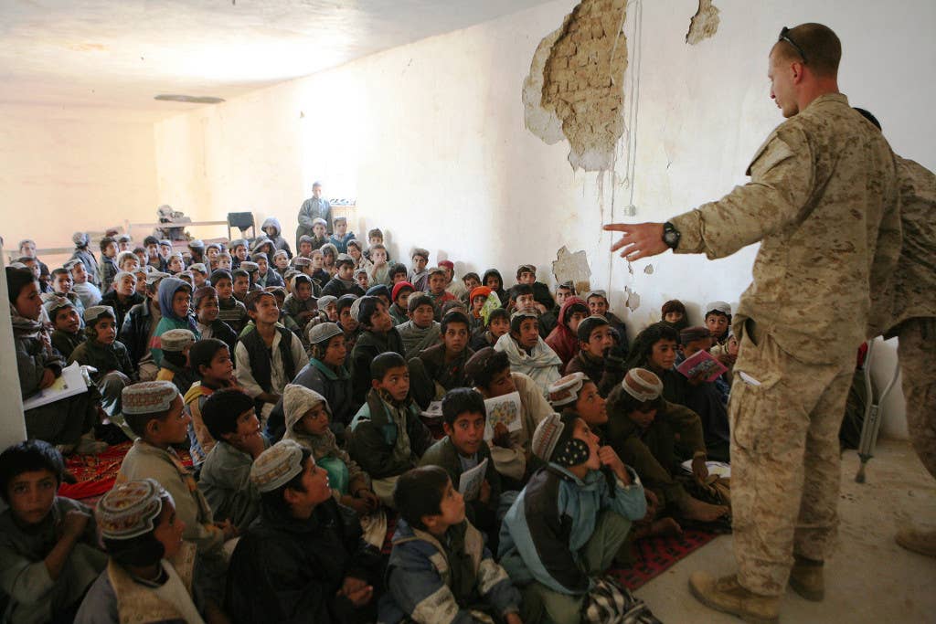 With the help of an interpreter, Capt. Jason Brezler addresses a group of schoolchildren in Now Zad, Afghanistan in 2009. (Photo: U.S. Army)