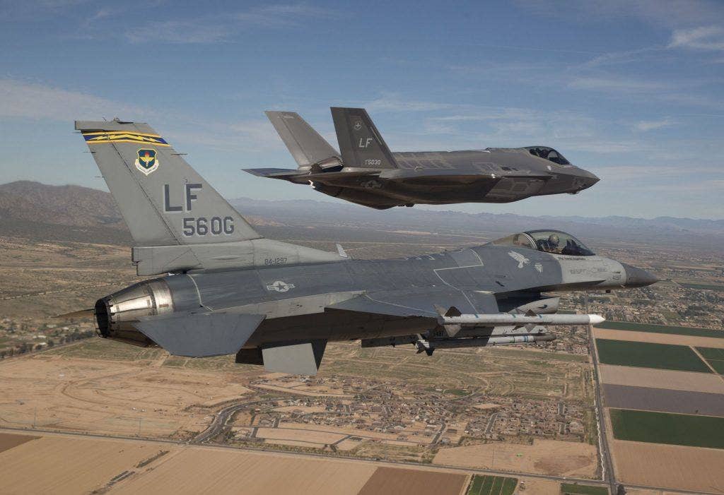 Maj. Justin Robinson flying the 56th Operations Group flagship F-16 Fighting Falcon, escorting the first F-35 Lightning II to Luke Air Force Base in Arizona in 2014. | US Air Force photo