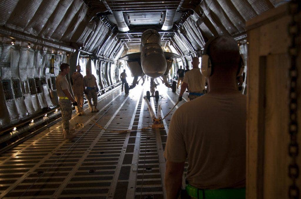 Members of the 451st Expeditionary Logistics Readiness Squadron aerial port flight and 22nd Airlift Squadron prepare to load a US Navy F/A-18 Super Hornet fighter aircraft onto a US Air Force C-5 Galaxy cargo aircraft on Kandahar Airfield, Afghanistan, August 18, 2011. | US Air Force photo