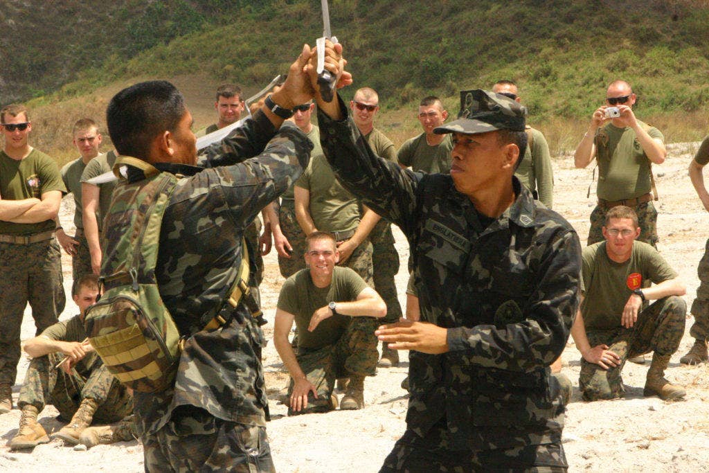 Tech Sgt. Manuel S Prado Jr. (left), a chief master instructor, and Staff Sgt. Carlito M Englatiera Jr. (right), a martial arts instructor, both with the Republic of the Philippines Marine Corps Martial Arts Program demonstrate Pekithtirsia defense moves to U.S. Marines with Battalion Landing Team 2nd Battalion, 7th Marines (BLT 2/7), 31st Marine Expeditionary Unit. (Marine Corps photo by Cpl. Michael A. Bianco)