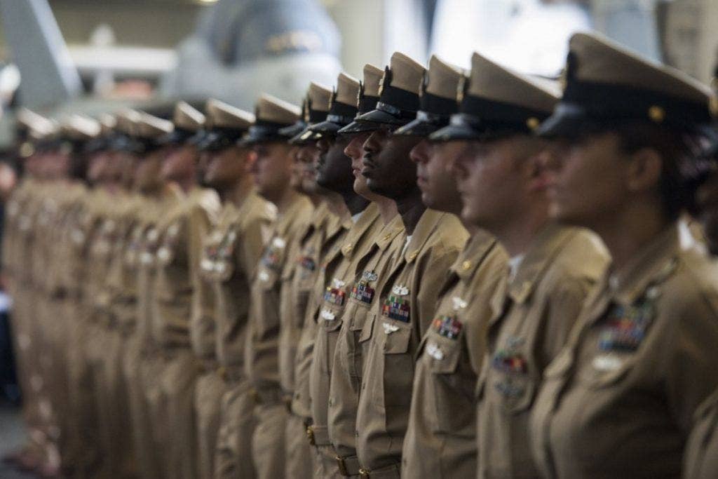 Chief petty officers stand at attention during a chief pinning ceremony aboard the aircraft carrier USS George H.W. Bush (CVN 77) on Sept. 16, 2016, in the Atlantic Ocean. | U.S. Navy photo by Christopher Gaines