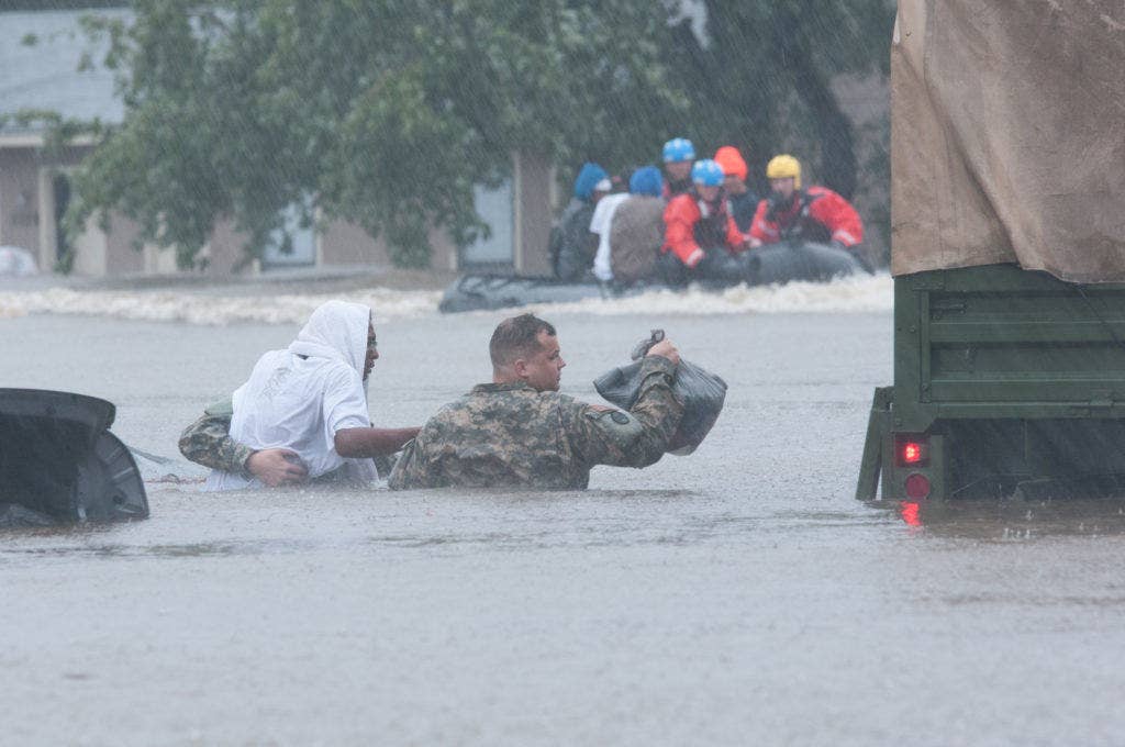 North Carolina Army National Guard Staff Sgt. Joshua Carr, a land combat electronics technician with the 230th Brigade Support Battalion, and local emergency services assist with evacuation efforts in Fayetteville, N.C., Oct. 08, 2016. Heavy rains caused by Hurricane Matthew led to flooding as high as five feet in some areas. (U.S. Army National Guard photo by Staff Sgt. Jonathan Shaw, 382nd Public Affairs Detachment)