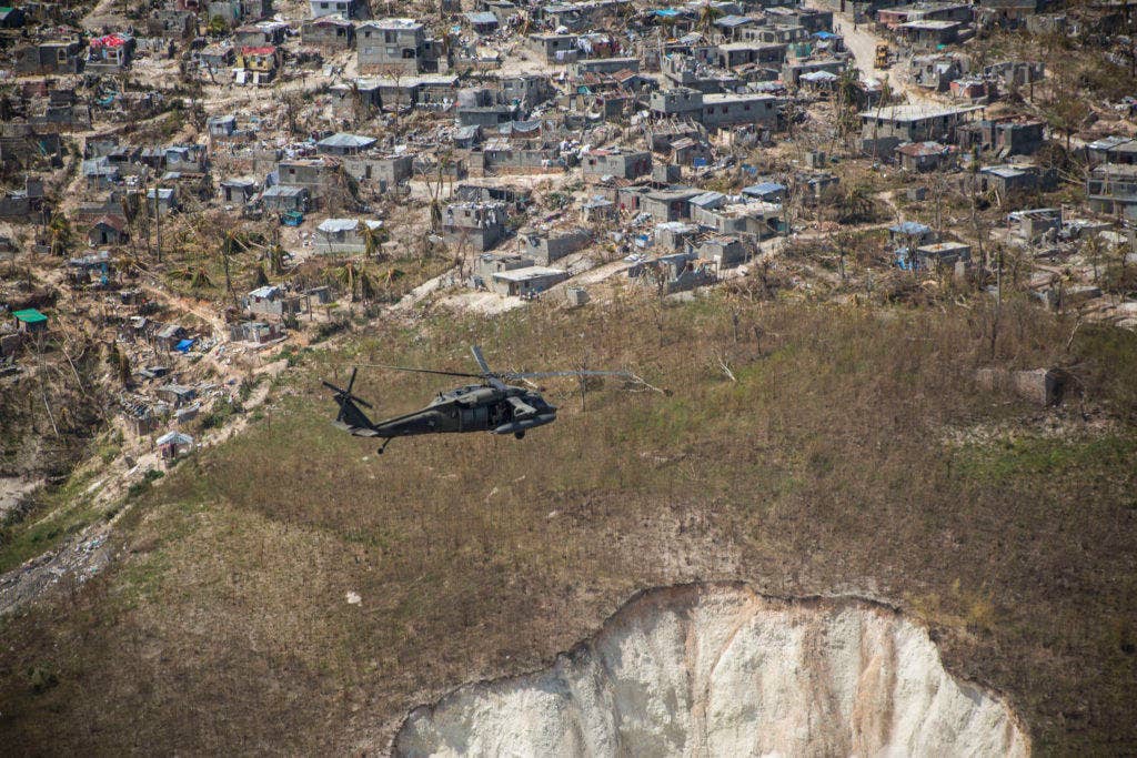 A U.S. Army UH-60 Black Hawk helicopter with Joint Task Force-Bravo's 1st Battalion, 228th Aviation Regiment, deployed in support of Joint Task Force Matthew, flies toward a supply distribution point in Jeremie, Haiti, Oct. 10, 2016. JTF Matthew, a U.S. Southern Command-directed team, is comprised of Marines with Special Purpose Marine Air-Ground Task Force - Southern Command and soldiers from JTF-Bravo, and is deployed to Port-au-Prince at the request of the Government of Haiti on a mission to provide humanitarian and disaster relief assistance in the aftermath of Hurricane Matthew. (U.S. Marine Corps photo by Cpl. Kimberly Aguirre)