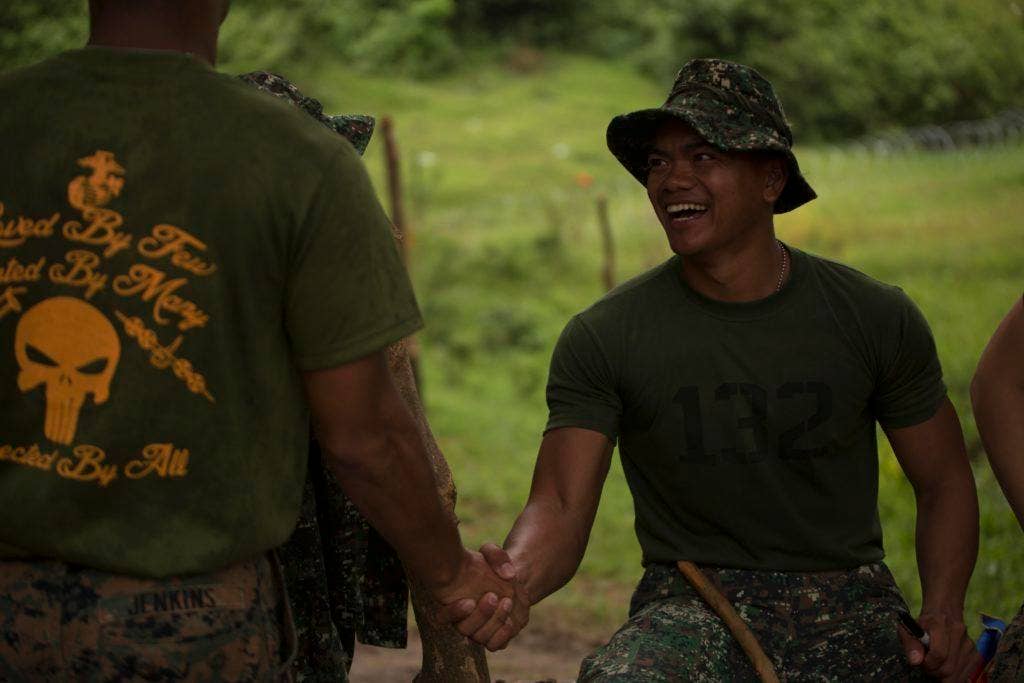 Philippine Marine Pfc. Japeth Inocencio, from Jamindan, Philippines, shakes hands with U.S. Marine Cpl. Todd Jenkins, from Long Beach, Calif., at Colonel Ernesto Ravina Air Base, Philippines, during Philippine Amphibious Landing Exercise 33 (PHIBLEX), Oct. 10, 2016. (U.S. Marine Corps photo by Lance Cpl. Nelson Duenas/Released)